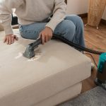 limpiando una mancha del sofá con una aspiradora de tapicerías